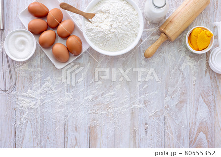 Homemade dough recipe (eggs, flour, milk, sugar) on a wooden table top view. 80655352