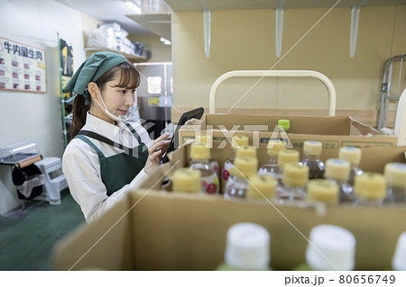 スーパーのバックヤードでマウスシールドをして作業をする女性従業員 80656749