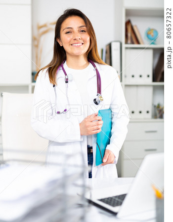 Portrait of friendly female doctor wearing white scrubs uniform Portrait of friendly female doctor wearing white scrubs uniform 80657322