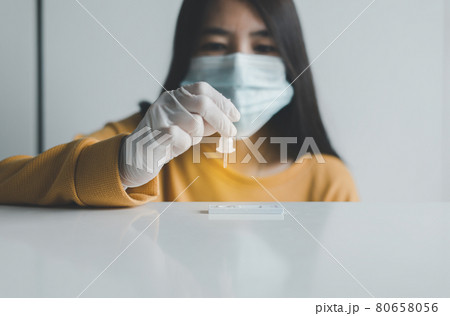 Asian patient woman using a covid-19 self test rapid antigen testing kit at home Asian patient woman using a covid-19 self test rapid antigen testing kit at home 80658056