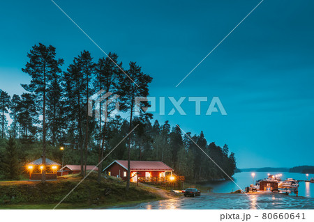 Sweden. Sweden. Beautiful Red Swedish Wooden Log Cabin House On Rocky Island Coast In Summer Night Evening. Lake Or River Landscape. Beautiful Wooden Pier Near Lake In Summer Evening Night. Lake Or 80660641