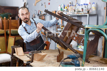 Restorer inspecting antique armchair Restorer inspecting antique armchair 80661140