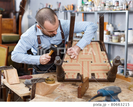 Carpenter repairing antique chair Carpenter repairing antique chair 80663215