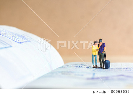 Miniature people couple standing on passport with immigration stamped , Miniature people couple standing on passport with immigration stamped , 80663655
