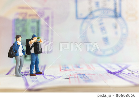 Miniature people couple standing on passport with immigration stamped , Miniature people couple standing on passport with immigration stamped , 80663656