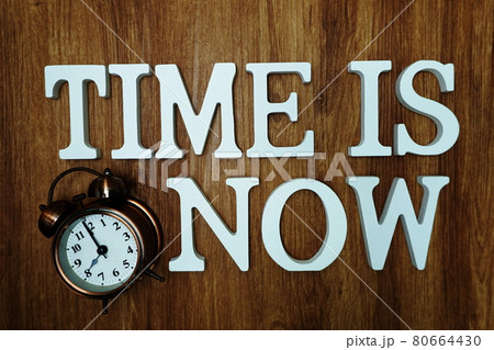 Time Is Now alphabet letter with alarm clock on wooden background Time Is Now alphabet letter with alarm clock on wooden background 80664430