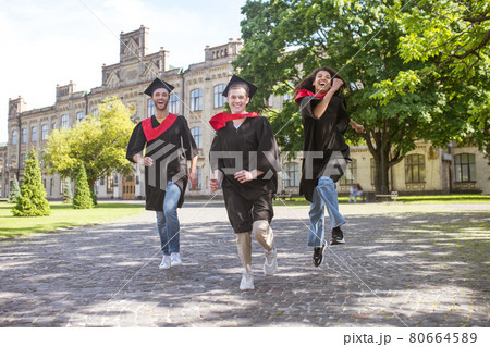 Three graduates running in the park and having fun Three graduates running in the park and having fun 80664589