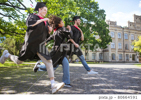 A group of graduates in the park feeling great and excited A group of graduates in the park feeling great and excited 80664591