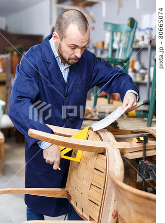 Craftsman making drawing of vintage chair 80665074