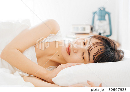 ベッドで寝る女性 80667923
