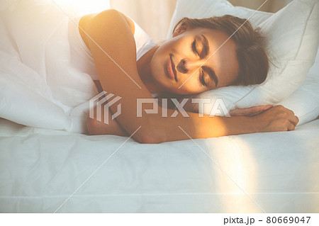 Beautiful blonde girl sleeping sweetly in sunny bedroom on a white bed. Holyday comfort and Rest concepts Beautiful blonde girl sleeping sweetly in sunny bedroom on a white bed. Holyday comfort and Rest concepts 80669047