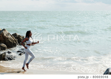 Sportswoman Jogging on Beautiful Beach 80669048