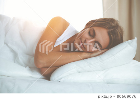 Beautiful blonde girl sleeping sweetly in the bedroom on a white bed. Comfort and Rest concepts Beautiful blonde girl sleeping sweetly in the bedroom on a white bed. Comfort and Rest concepts 80669076