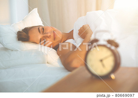 Beautiful blonde girl sleeping sweetly in sunny bedroom on a white bed. Holyday comfort and Rest concepts 80669097