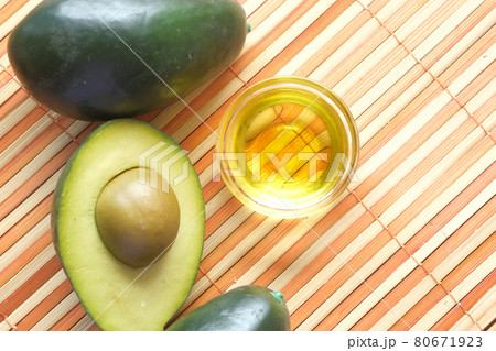 Top view of oil and slice of avocado on wooden table Top view of oil and slice of avocado on wooden table 80671923