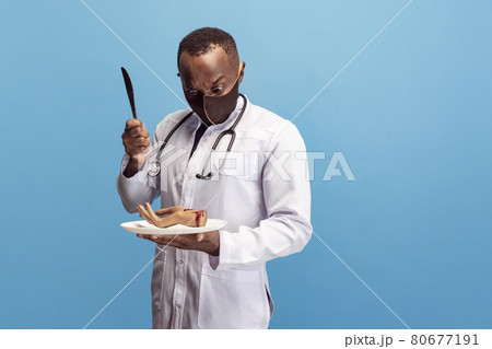 Young doctor, therapeutic or medical advisor having fun isolated on blue studio back ground. Funny meme emotions. Concept of healthcare, care, medicine and humor. Young doctor, therapeutic or medical advisor having fun isolated on blue studio back ground. Funny meme emotions. Concept of healthcare, care, medicine and humor. 80677191