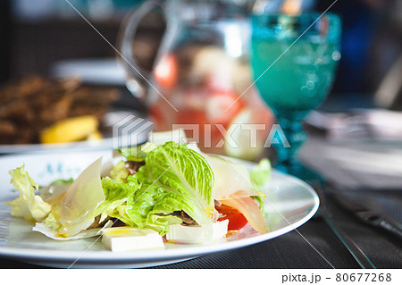 Close up of salad with lettuce, tomatoes and cheese on a white plate Close up of salad with lettuce, tomatoes and cheese on a white plate 80677268