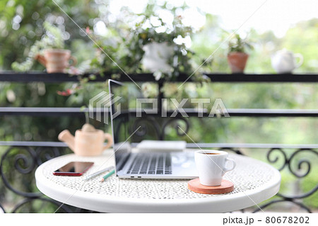 Silver laptop side view white mock and coffee cup with notebooks on white table outdoor 80678202
