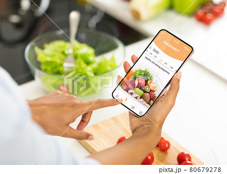 Black pregnant woman using mobile app with diet for pregnancy Black pregnant woman using mobile app with diet for pregnancy 80679278