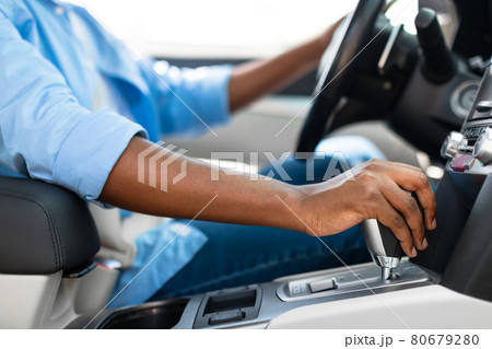 Unrecognizable black man driving new car in city Unrecognizable black man driving new car in city 80679280