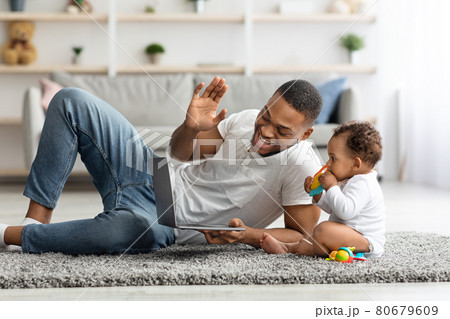 Black Dad And Infant Baby Making Video Call With Laptop At Home 80679609