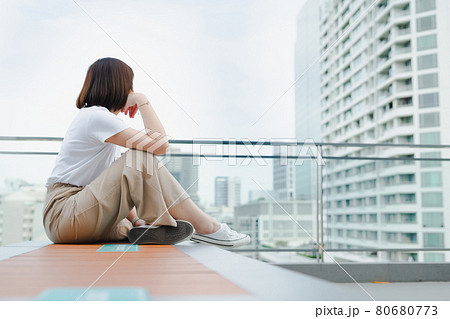 solo asian woman during outdoor break and relax at rooftop with city background 80680773