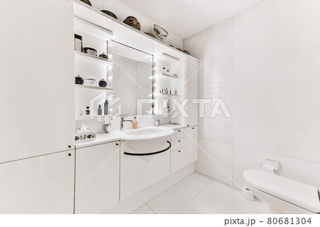 A spacious bathroom with white walls and huge mirror 80681304