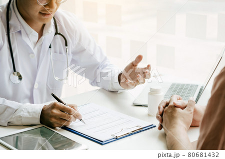 Asian doctor is examining the abnormal items of the body and diagnosing the disease in the paper with the medical report of the patient. 80681432