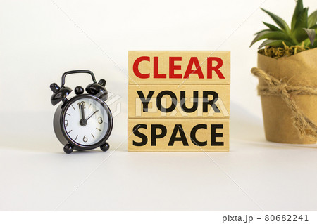 Clear your space symbol. Wooden blocks with words 'Clear your space'. Beautiful white background, black alarm clock, house plant. Business, clear your space concept, copy space. 80682241