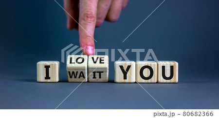 I love you symbol. Hand turns cubes and changes the expression 'I wait you' to 'I love you'. Beautiful grey background, copy space. Psychological and i love you concept. 80682366