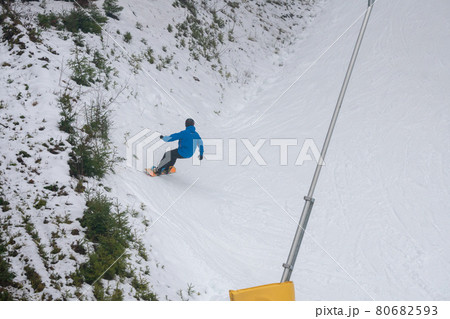 Snowboarder riding on White Snow Covered Slope top view Snowboarder riding on White Snow Covered Slope top view 80682593