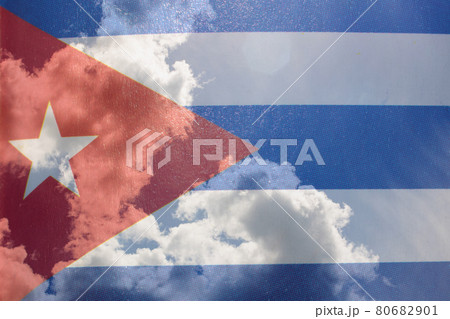 Cuba flag in hand on blue sky with clouds Cuba flag in hand on blue sky with clouds 80682901