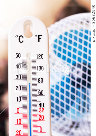 Small fan and room mercury thermometer closeup 80682940