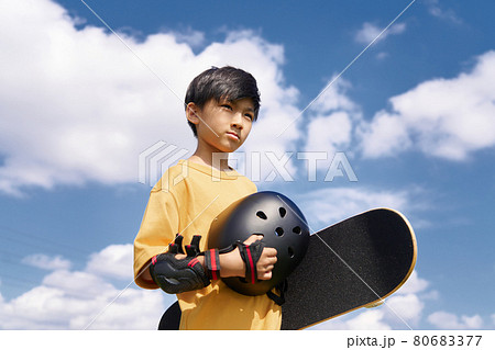 スケートボードを持って立つ少年 80683377