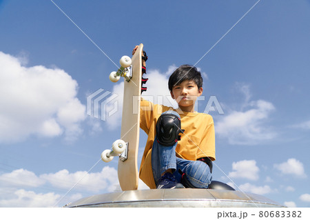 スケートボードを持って座る少年 スケートボードを持って座る少年 80683382