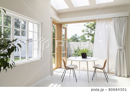 ノートパソコンの置かれたテーブルがあるサンルーム　ワーケーション　リモートワーク 　イメージ 80684301