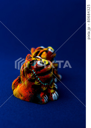 青をバックグラウンドにしたオレンジ色のシーサー 青をバックグラウンドにしたオレンジ色のシーサー 80684325