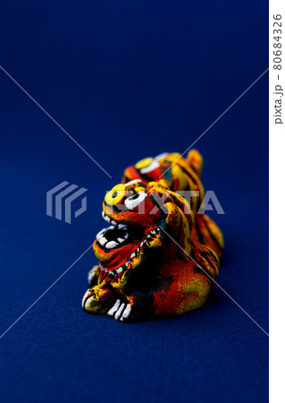 青をバックグラウンドにしたオレンジ色のシーサー 青をバックグラウンドにしたオレンジ色のシーサー 80684326