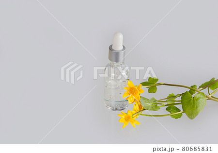 Cosmetic serum with bright yellow flowers on white background 80685831