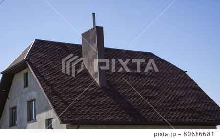 Brown corrugated metal profile roof installed on a modern house. The roof of corrugated sheet. Roofing of metal profile wavy shape. Modern roof made of metal. Metal roofing. 80686681