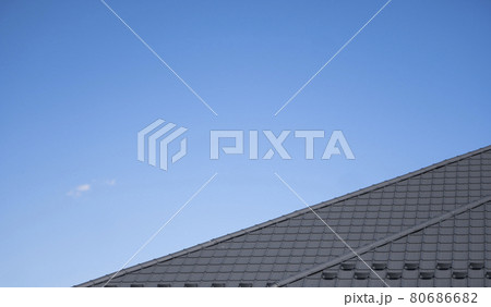 Brown corrugated metal profile roof installed on a modern house. The roof of corrugated sheet. Roofing of metal profile wavy shape. Modern roof made of metal. Metal roofing. 80686682