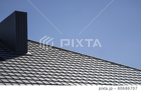 Brown corrugated metal profile roof installed on a modern house. The roof of corrugated sheet. Roofing of metal profile wavy shape. Modern roof made of metal. Metal roofing. Brown corrugated metal profile roof installed on a modern house. The roof of corrugated sheet. Roofing of metal profile wavy shape. Modern roof made of metal. Metal roofing. 80686707