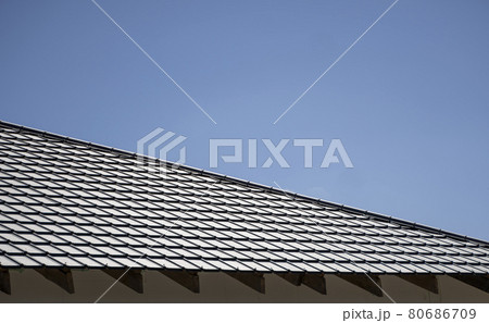 Brown corrugated metal profile roof installed on a modern house. The roof of corrugated sheet. Roofing of metal profile wavy shape. Modern roof made of metal. Metal roofing. 80686709