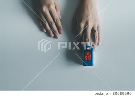 Patient women using fingertip pulse oximeter oxygen saturation meter SPO2 PR blood monitor finger on white background 80689696