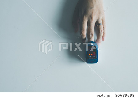 Patient women using fingertip pulse oximeter oxygen saturation meter SPO2 PR blood monitor finger on white background 80689698