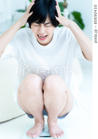 体重を計ってショックを受ける女性 体重を計ってショックを受ける女性 80690430