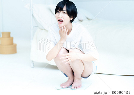 体重を計ってショックを受ける女性 体重を計ってショックを受ける女性 80690435