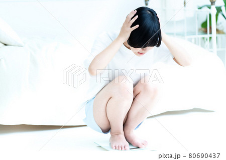体重を計ってショックを受ける女性 体重を計ってショックを受ける女性 80690437