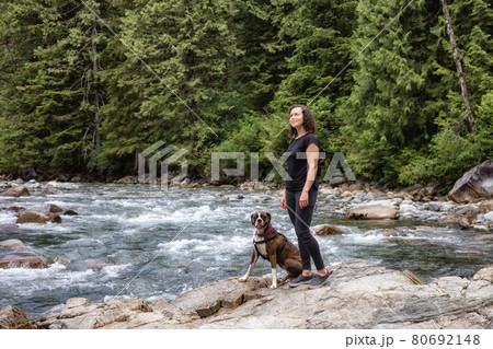 Woman hiking with Boxer Dog in the Canadian Nature Woman hiking with Boxer Dog in the Canadian Nature 80692148