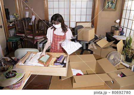 散らかった部屋の片付けをする女性作業員 80692780